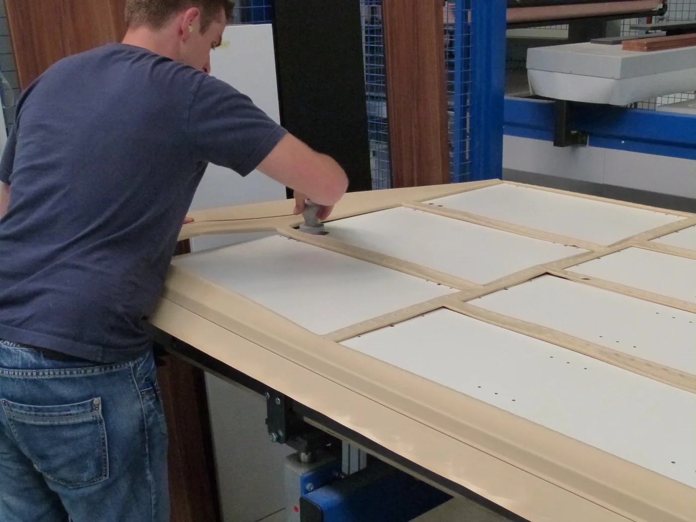 Employee cutting foil with the TK-1 knife on a furniture front