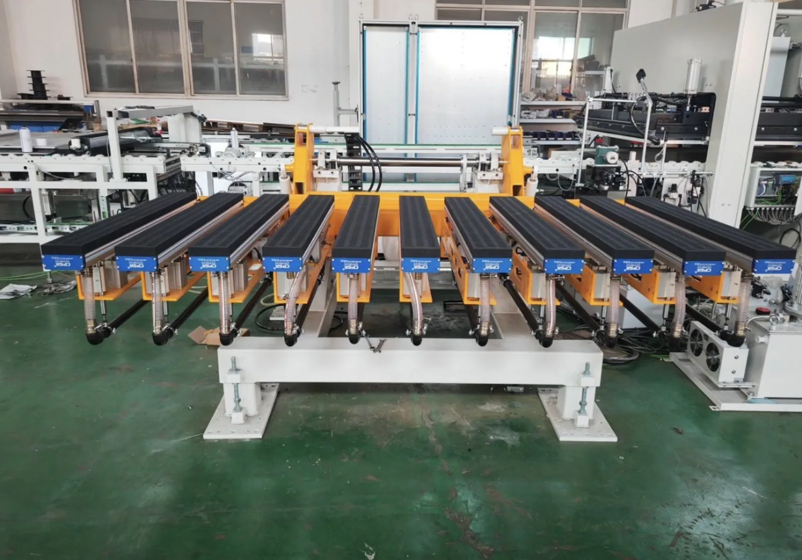 Orange turn-over system with nine padded arms in a production hall
